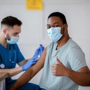 african american man in mask gesturing thumb up during coronavirus picture id1297769933